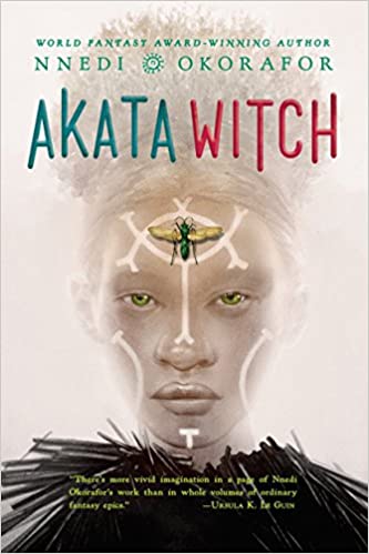 Cover of Akata Witch featuring an young albino Black girl with her hair in up in a puff, white markings on her face, and some sort of beetle on her forehead. 